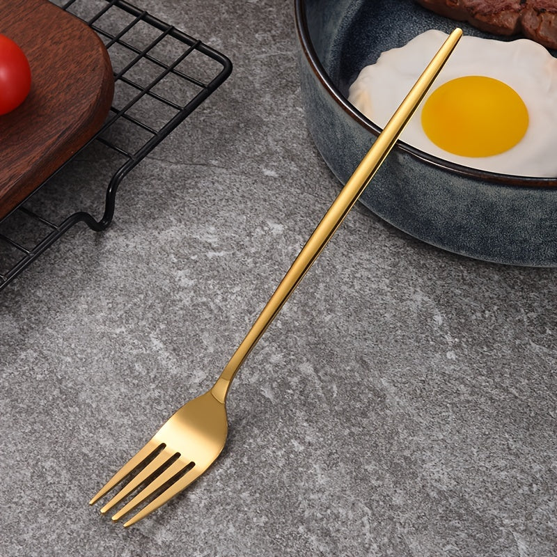 Gold fork on a gray surface with an egg and tomato in the background