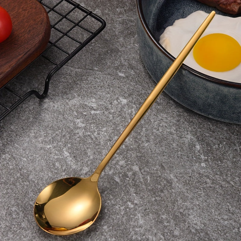 Gold spoon on a gray surface with a bowl of eggs in the background