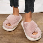 Pink fluffy slippers worn indoors on a wooden floor.