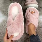 Pink fuzzy slippers being worn on a fluffy surface