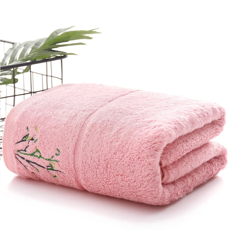 Folded pink towel with embroidery on a white background
