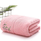Folded pink towel with embroidery on a white background