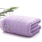 Folded purple towel with green embroidery on a white background