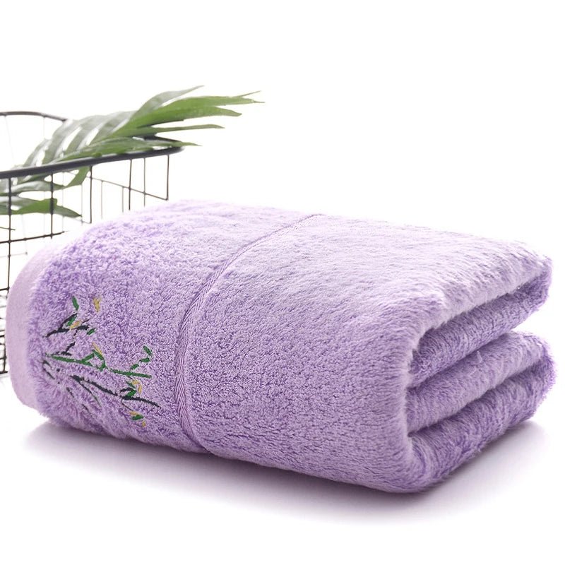 Folded purple towel with green embroidery on a white background