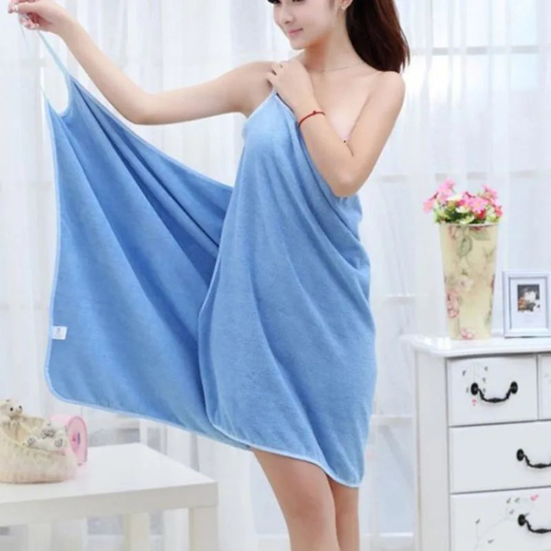 Woman holding a blue towel in a bright room with white furniture and decor.
