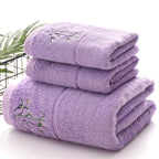 Stack of purple towels with embroidery on a white background