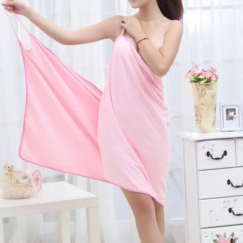 Woman holding a pink towel in a room with white furniture and decor.