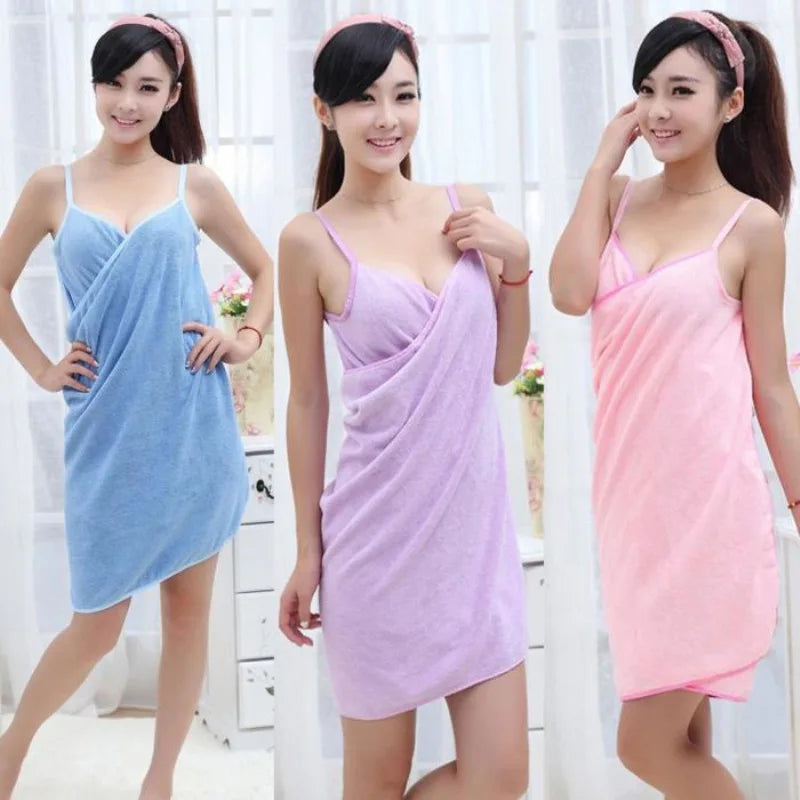 Three women wearing different colored towel dresses against a white background