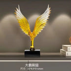 Decorative sculpture of a bird with outstretched wings on a dark surface.