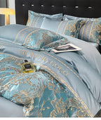 Teal bedding set with gold embroidery featuring 'Chanel' branding, on a bed with a black headboard.