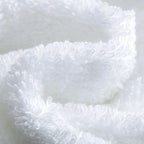 Close-up of white fluffy fabric on a light gray background