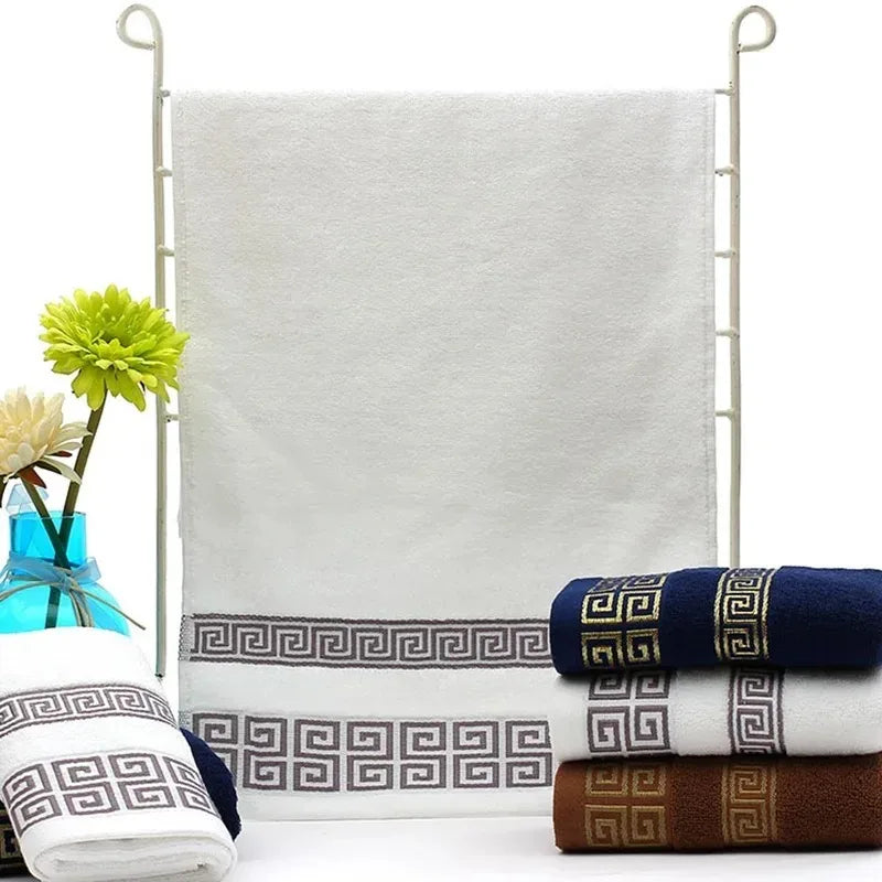 Set of patterned towels on a white background with a vase of flowers.