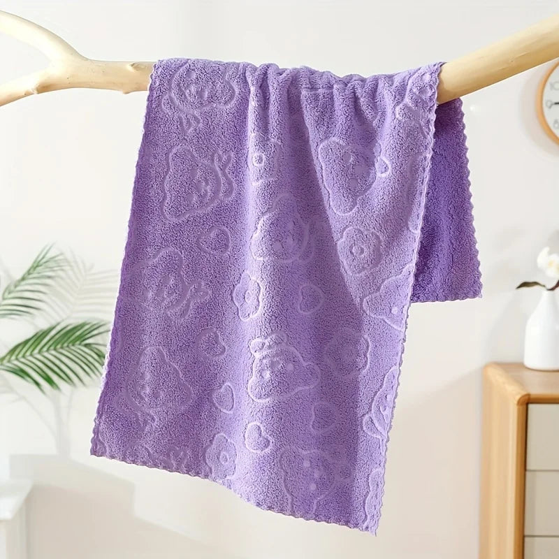 Purple textured towel hanging on a wooden rack against a light background