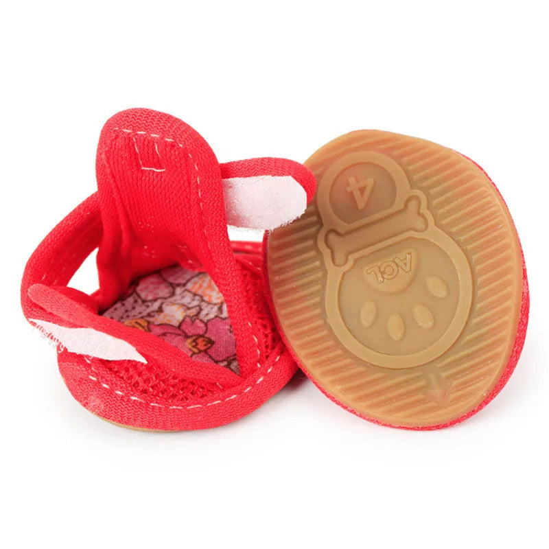Red pet shoes with a brown sole featuring a paw print design on a white background