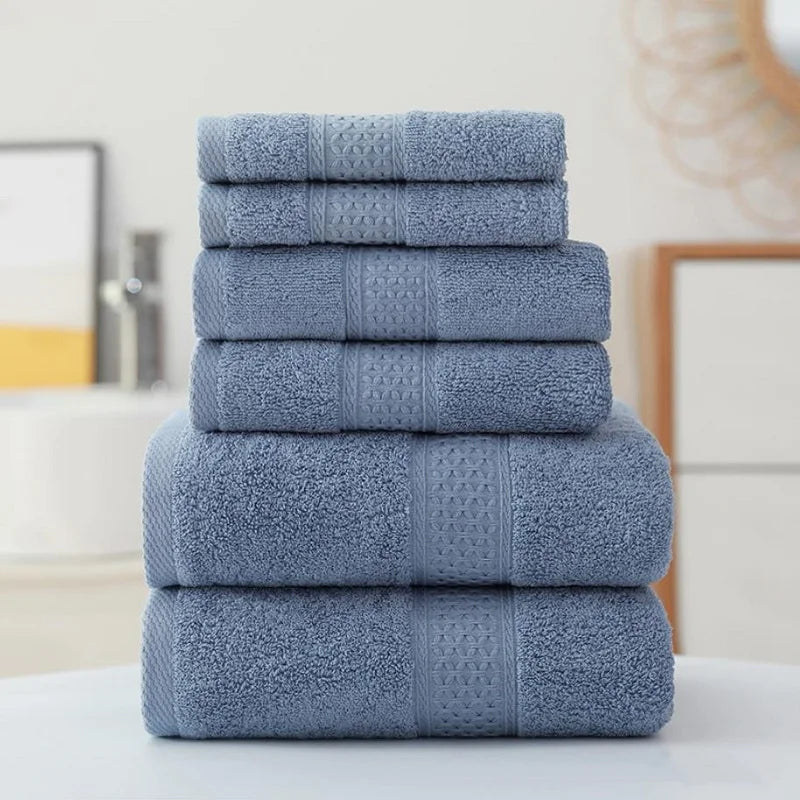 Set of blue towels stacked on a white surface with a neutral background