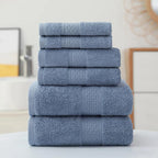Set of blue towels stacked on a white surface with a neutral background