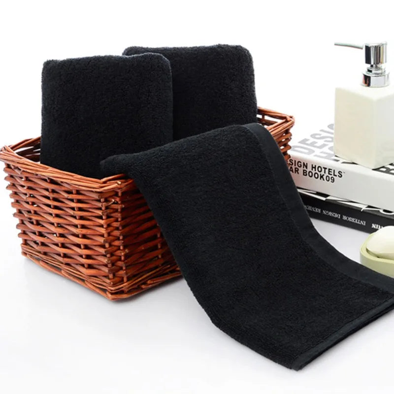 Black towels in a wicker basket with a white background