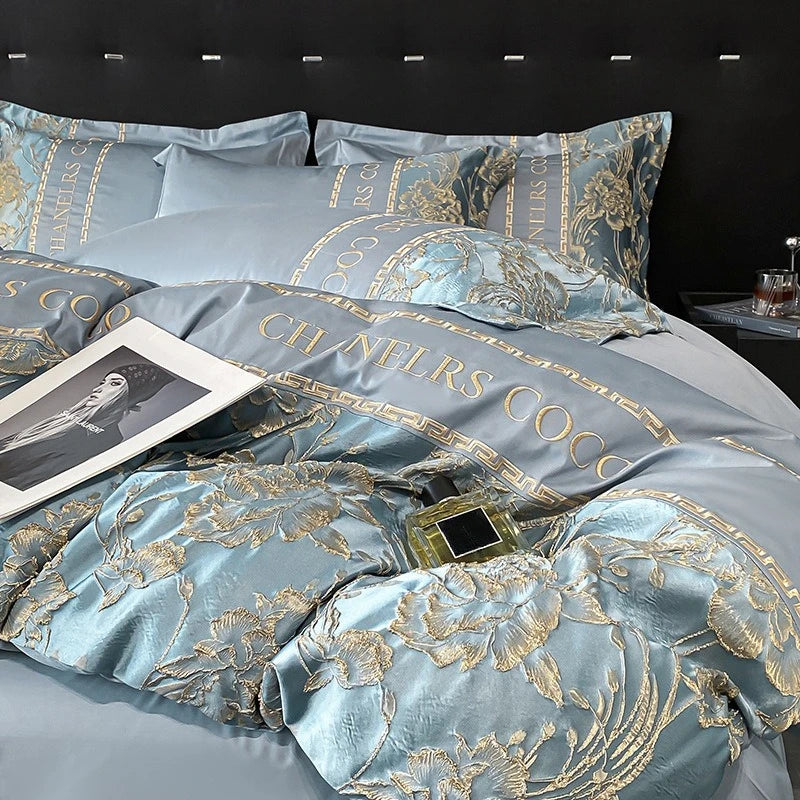 Luxurious bedspread with floral patterns and 'Chanters Coco' branding on a dark background.