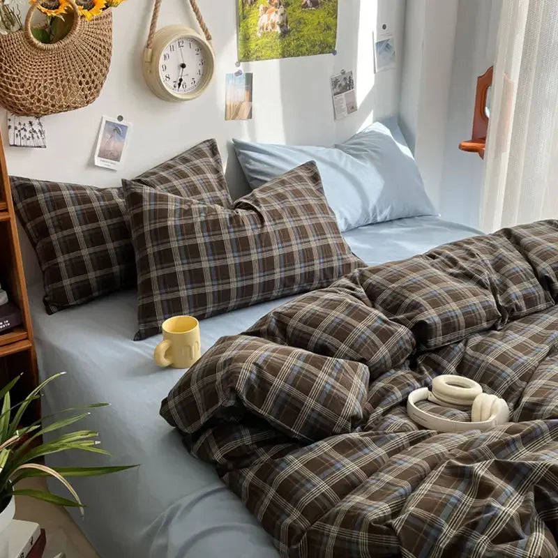 Bed with plaid bedding and pillows in a cozy bedroom setting.