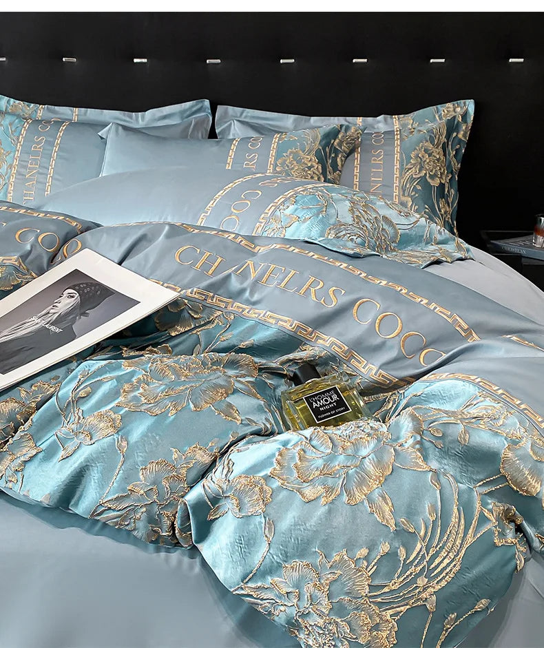 Luxurious turquoise and gold bedding set with a bottle of perfume on a bed.