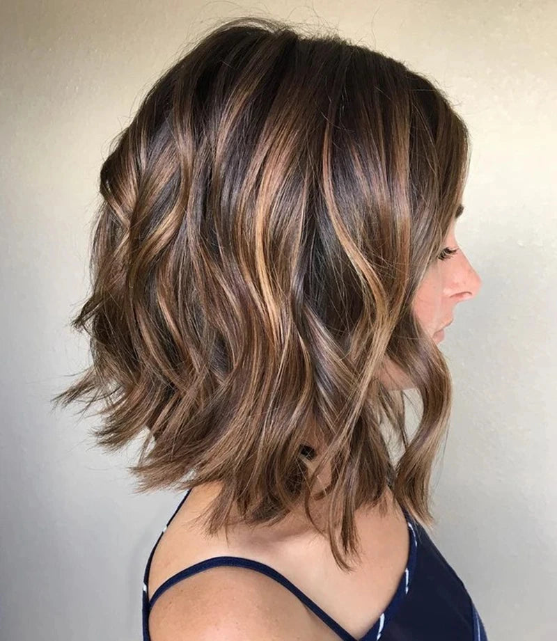Side profile of a person with shoulder-length hair with brown and blonde balayage on a plain background