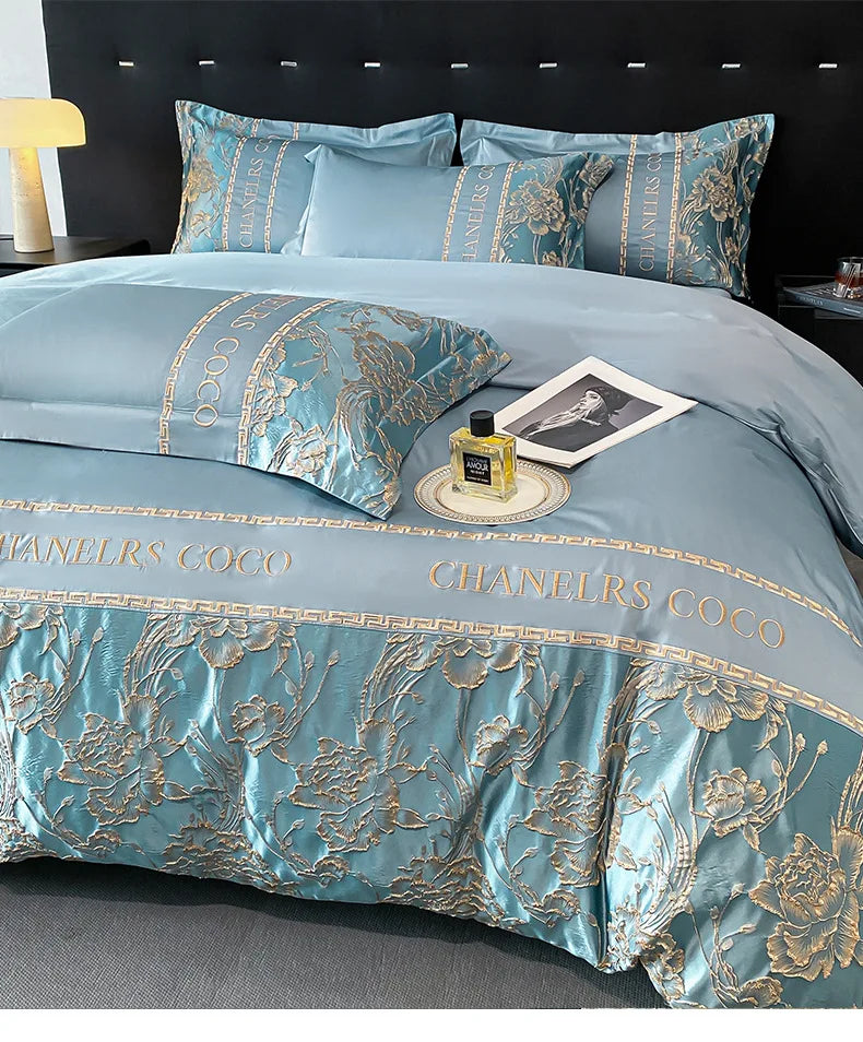 Luxurious blue and gold bedding set with 'Chanel' branding on a bed.