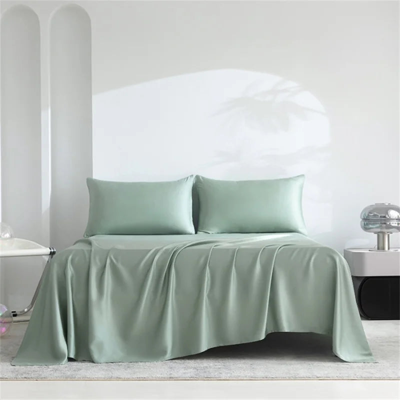 Green satin sheet set on a bed with a white headboard.