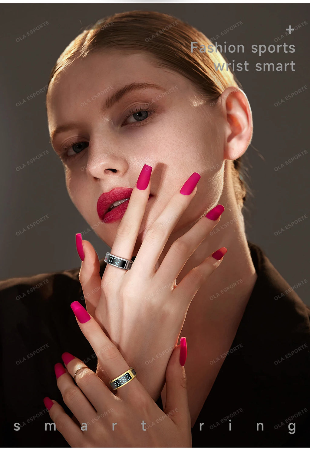 Woman with pink nails and rings, wearing a black top against a dark background.