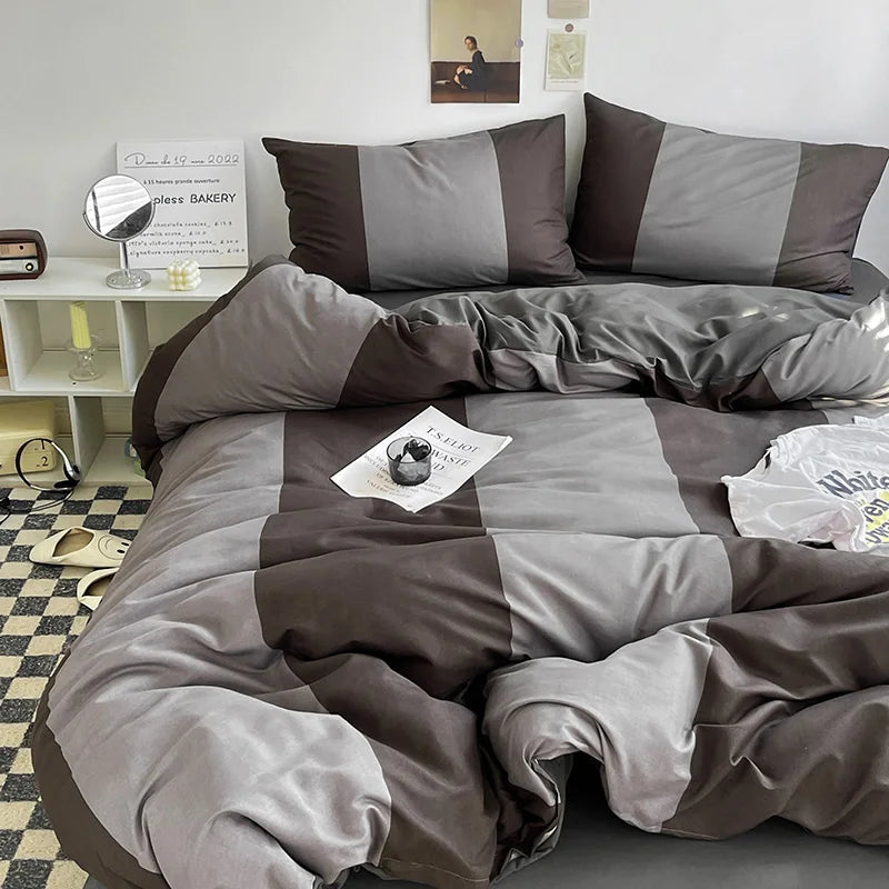 Gray and brown checkered bedding set on a bed in a room with a mirror and shelf.
