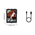 Small electronic device with a screen displaying a person, next to a USB cable on a white background.