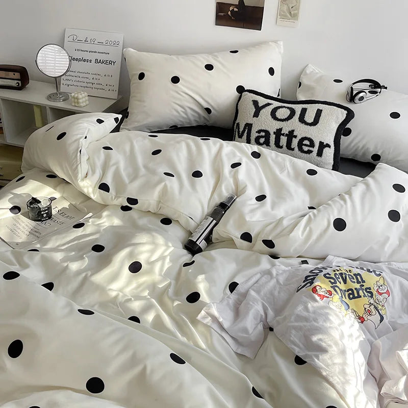 White polka dot bedding set on a bed with a pillow that says 'You Matter'.
