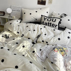 White polka dot bedding set on a bed with a pillow that says 'You Matter'.