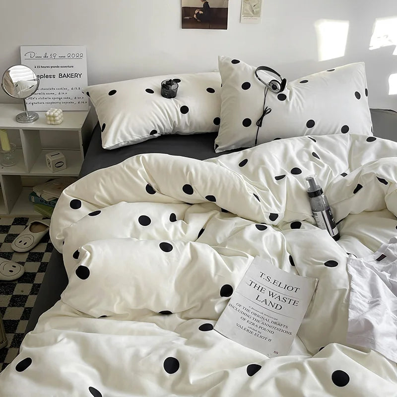 Polka dot bedding set on a bed with a book titled 'The Waste Land' in a bedroom setting.