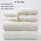 Set of six white towels including washcloths, hand towels, and bath towels on a light gray background.