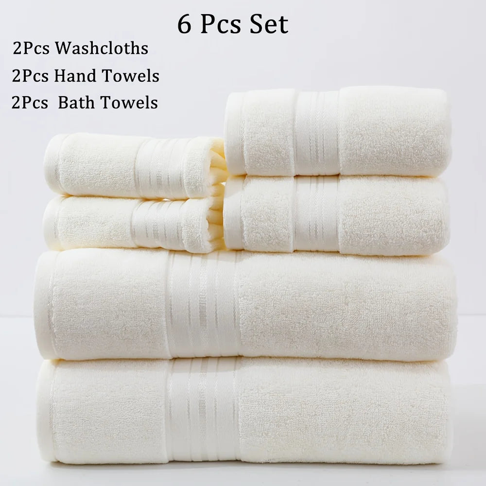 Set of six white towels including washcloths, hand towels, and bath towels on a light gray background.