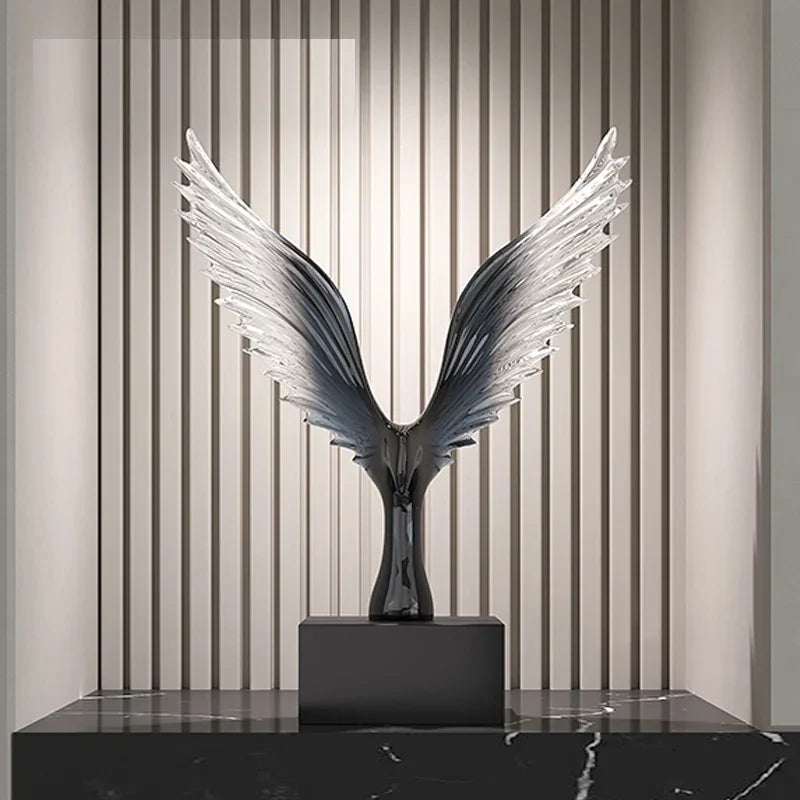 Decorative sculpture with wing-like design on a black platform against a striped wall.