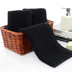 Black towels in a wicker basket with a white background