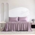 Purple satin bedding set on a bed with a white headboard.