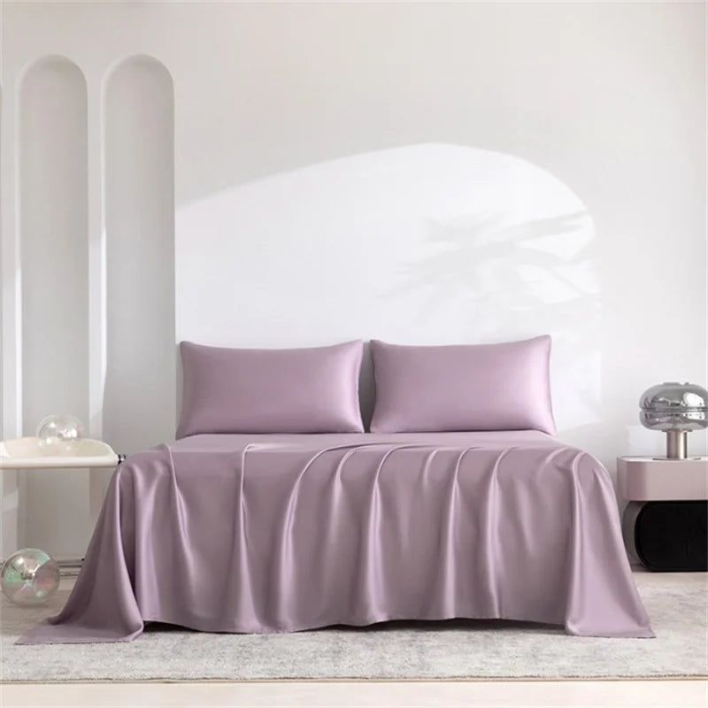 Purple satin bedding set on a bed with a white headboard.