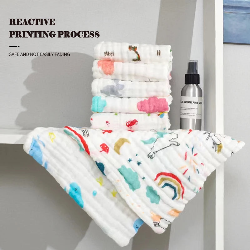 Stack of colorful baby blankets with a spray bottle on a white surface, featuring text about reactive printing process.