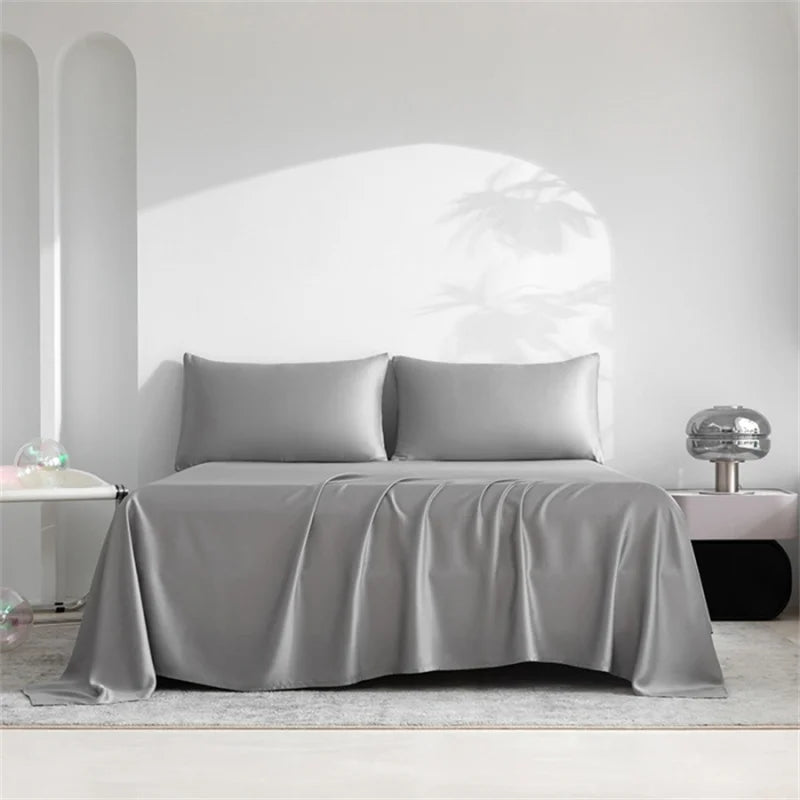Gray satin bedding set on a bed in a minimalistic room.