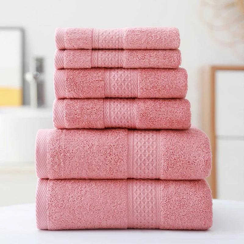 Stack of pink towels on a white surface with a neutral background
