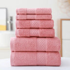 Stack of pink towels on a white surface with a neutral background