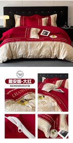 Red and gold bedding set with 'Chanel' branding on a bed.