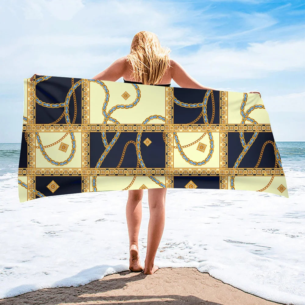 Person holding a decorative towel on a beach with ocean and sky in the background