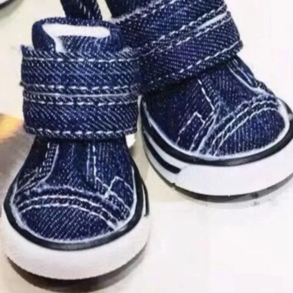 Pair of blue denim dog boots on a white background