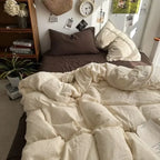 Neatly made bed with white comforter and pillows in a cozy bedroom setting.