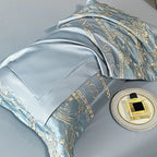 Luxury satin bedding set with gold embroidery on a gray background