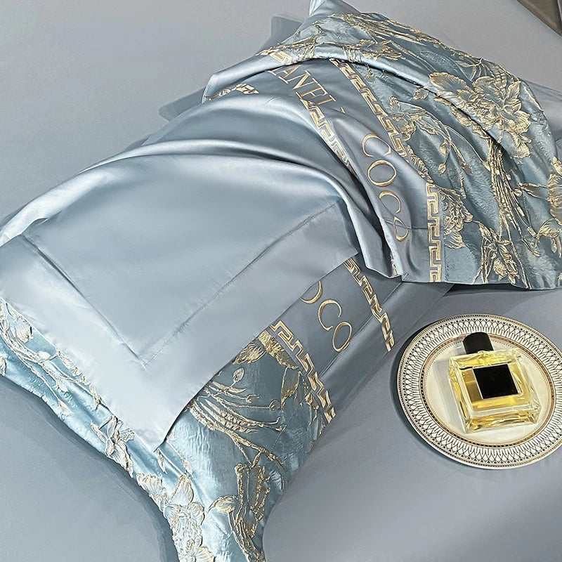 Luxury satin bedding set with gold embroidery on a gray background