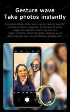 Smart ring with camera app on smartphone screen, showing two people taking a selfie.
